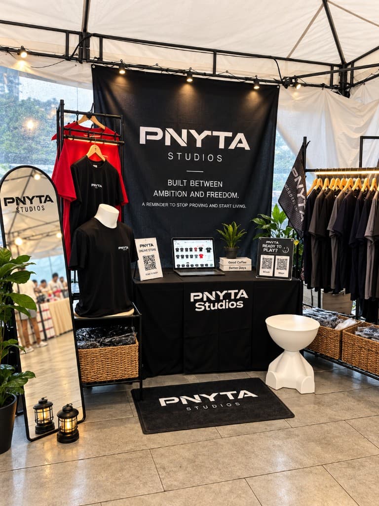 PNYTA Studios pop-up booth with racks, scan-to-shop, and the brand floor mat