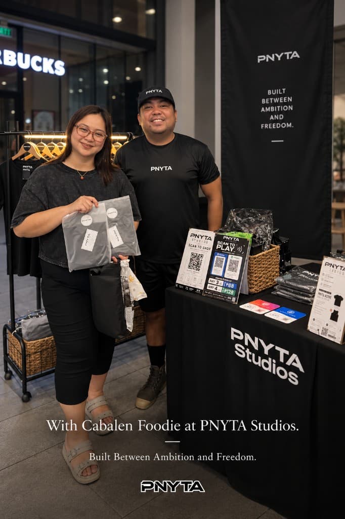 Cabalen Foodie at the PNYTA Studios booth, holding packaged shirts